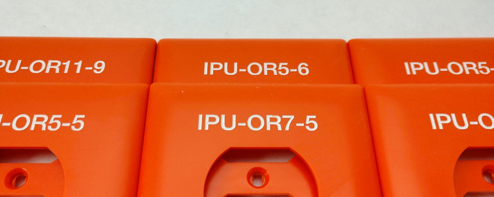 Paint-filled Switchplates, Paintfilled Switch Plates Image. Orange Thermoplastic (Nylon) Outlet Cover Plates with Laser Engraved Lettering with a White Paint-Fill